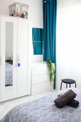 a bedroom with a bed and a blue curtain at Lima Residence in Nicosia