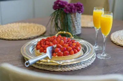 a plate of strawberries on a table with two glasses of orange juice at Stavri De'Lux Apartment in Larnaka