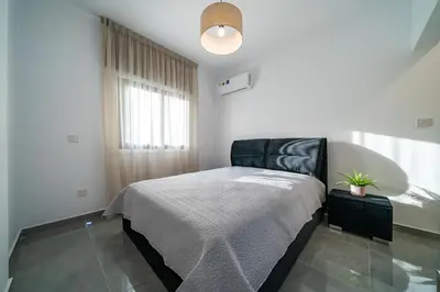 a bedroom with a bed and a potted plant at Stavri De'Lux Apartment in Larnaka
