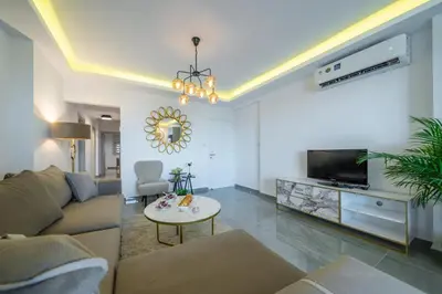 a living room with a couch and a tv and a table at Stavri De'Lux Apartment in Larnaka