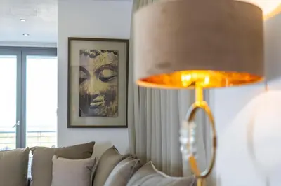 a lamp in a living room with a couch at Stavri De'Lux Apartment in Larnaka