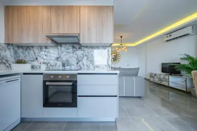 a kitchen with white cabinets and a stove top oven at Stavri De'Lux Apartment in Larnaka