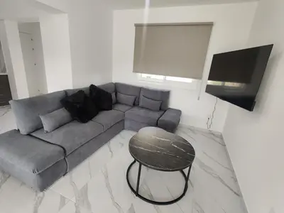 a living room with a gray couch and a table at Maestro I Apartment in Larnaka