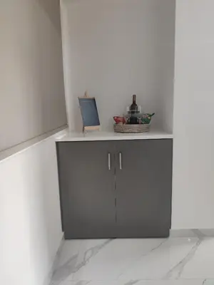 a white room with a cabinet with a laptop on it at Maestro I Apartment in Larnaka