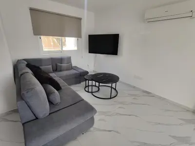 a living room with a couch and a table at Maestro I Apartment in Larnaka