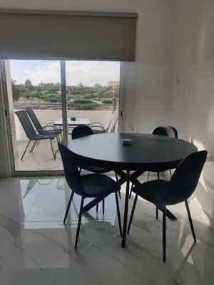 a black table and chairs in a room with a window at Maestro I Apartment in Larnaka