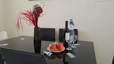 a table with a plate of apples and wine glasses at Dream Beach House Steps from the Sea & Free Parking in Protaras