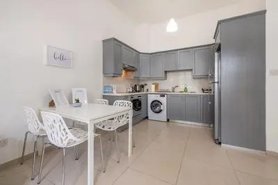 a kitchen with a white table and white chairs at Pageant Homes in Nicosia