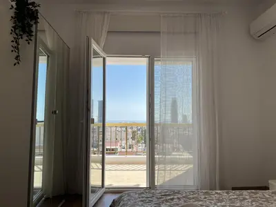 a bedroom with a bed and a large glass door at Sunny Rooms in Limassol
