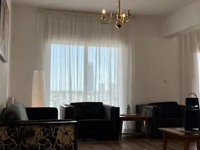 a living room with a couch and a large window at Sunny Rooms in Limassol
