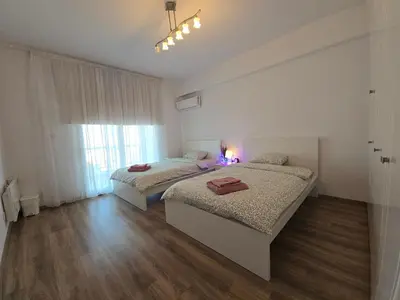 a bedroom with two beds and a window at Sunny Rooms in Limassol