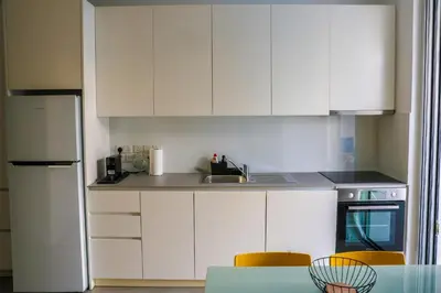 a kitchen with white cabinets and a table and chairs at Luxury Stay in Engomi