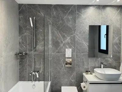 a bathroom with a shower and a sink at Phaedrus Living: White Hills Suites City View in Aglantzia