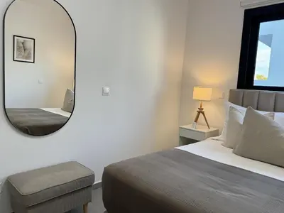 a bedroom with a large mirror and a bed at Phaedrus Living: White Hills Suites City View in Aglantzia
