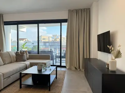 a living room with a couch and a table at Phaedrus Living: White Hills Suites City View in Aglantzia