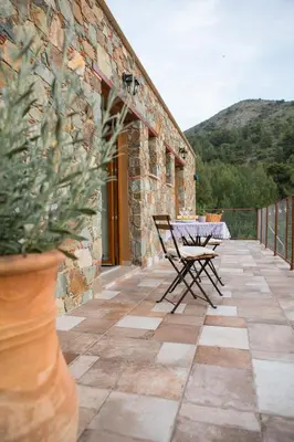 a patio with a table and chairs on a building at Fikardou Chalets in Phikardhou