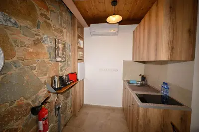 a kitchen with a stone wall and a sink at Fikardou Chalets in Phikardhou