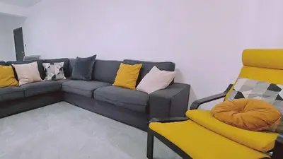 a living room with a couch and a yellow chair at STAY Centro Apartment in Larnaka