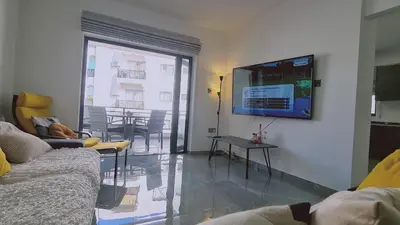 a living room with a couch and a tv on a wall at STAY Centro Apartment in Larnaka
