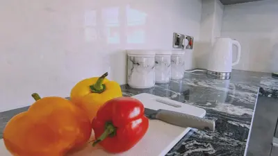 two tomatoes sitting on a cutting board next to a knife at STAY Centro Apartment in Larnaka