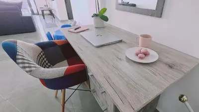 a wooden table with a laptop and a plate of food at STAY Centro Apartment in Larnaka