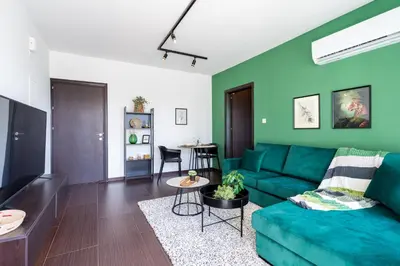 a living room with a green couch and a table at Harbor Apartments in Larnaca in Larnaka