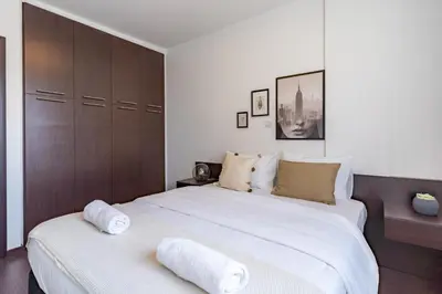 a bedroom with a large bed with two towels on it at Harbor Apartments in Larnaca in Larnaka