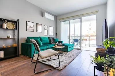 a living room with a green couch at Harbor Apartments in Larnaca in Larnaka