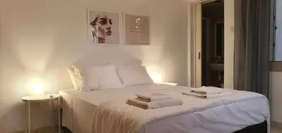 a bedroom with a white bed with towels on it at BLUE LUXURY APARTMENT (BREAKBOOKING CY-SERVICES LTD) in Limassol