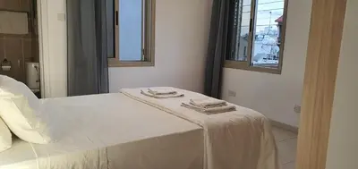 a white bed with two towels on top of it at BLUE LUXURY APARTMENT (BREAKBOOKING CY-SERVICES LTD) in Limassol