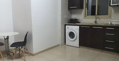 a kitchen with a washing machine and a table at BLUE LUXURY APARTMENT (BREAKBOOKING CY-SERVICES LTD) in Limassol