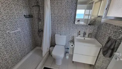a bathroom with a toilet and a sink and a shower at Stylish Beach Apt w/ Sea View + Pool + 200Mbit in Larnaka