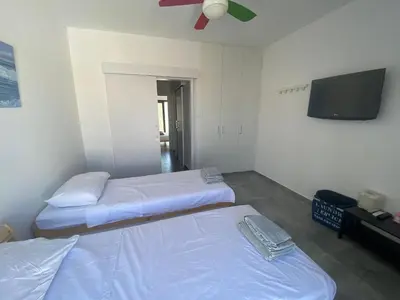a room with two beds and a flat screen tv at Green Bay Area Apartment in Protaras