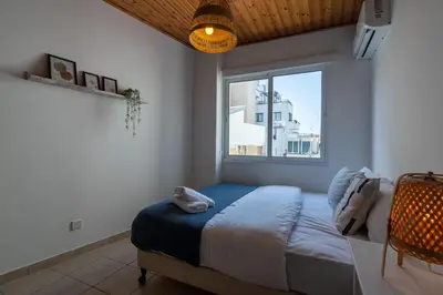 a bedroom with a bed and a large window at Laurel 2-Bedroom Apartment in Larnaca in Larnaka