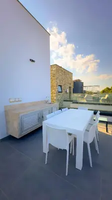 a white table and white chairs on a balcony at Luxury Beachfront Villa - Rooftop Jacuzzi, Sunrise in Paralimni