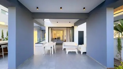 an open living room with white chairs and tables at Luxury Beachfront Villa - Rooftop Jacuzzi, Sunrise in Paralimni