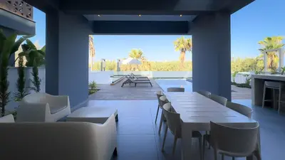 a restaurant with tables and chairs and a patio at Luxury Beachfront Villa - Rooftop Jacuzzi, Sunrise in Paralimni