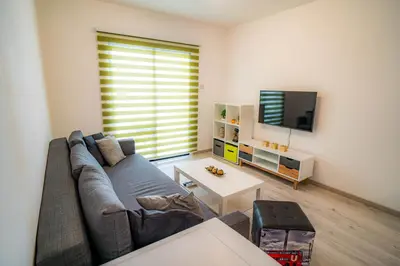 a living room with a couch and a tv at Cozy Apartment In Kapparis in Paralimni