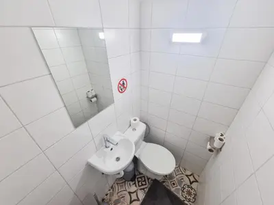 a white bathroom with a sink and a toilet at Larnaca Garden Rooms in Larnaka