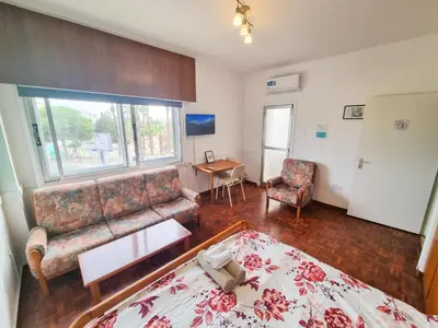 a living room with a couch and a table at Larnaca Garden Rooms in Larnaka