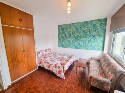 a living room with a couch and a bed at Larnaca Garden Rooms in Larnaka