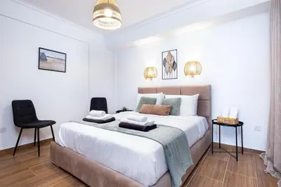 a bedroom with a large bed and two chairs at Quattro Beachfront Sea View Ap 206 in Larnaka