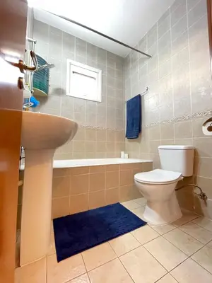 a bathroom with a toilet and a sink and a tub at Anastasia Holiday Apartment Larnaca in Larnaka