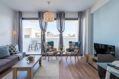 a living room with a couch and chairs and a tv at Livia Studio Apartment in Larnaca in Larnaka