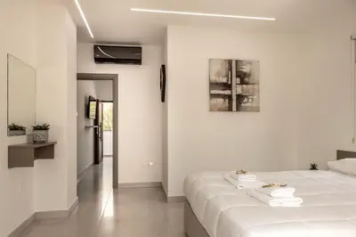 a white bedroom with a bed with towels on it at SEVIS SUITES in Ayia Napa