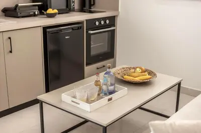 a kitchen with a table with drinks and a bowl of fruit at SEVIS SUITES in Ayia Napa
