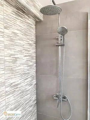a shower with a shower head in a bathroom at Sea the Sunrise in Larnaka