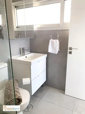 a bathroom with a sink and a toilet and a mirror at Sea the Sunrise in Larnaka