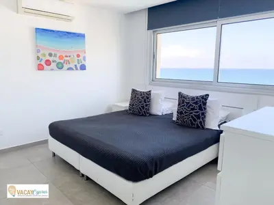 a bedroom with a bed and a window at Sea the Sunrise in Larnaka