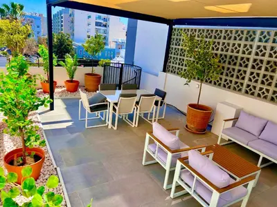 a patio with a table and chairs and plants at Bridge House 201 - 3BR Penthouse in Limassol